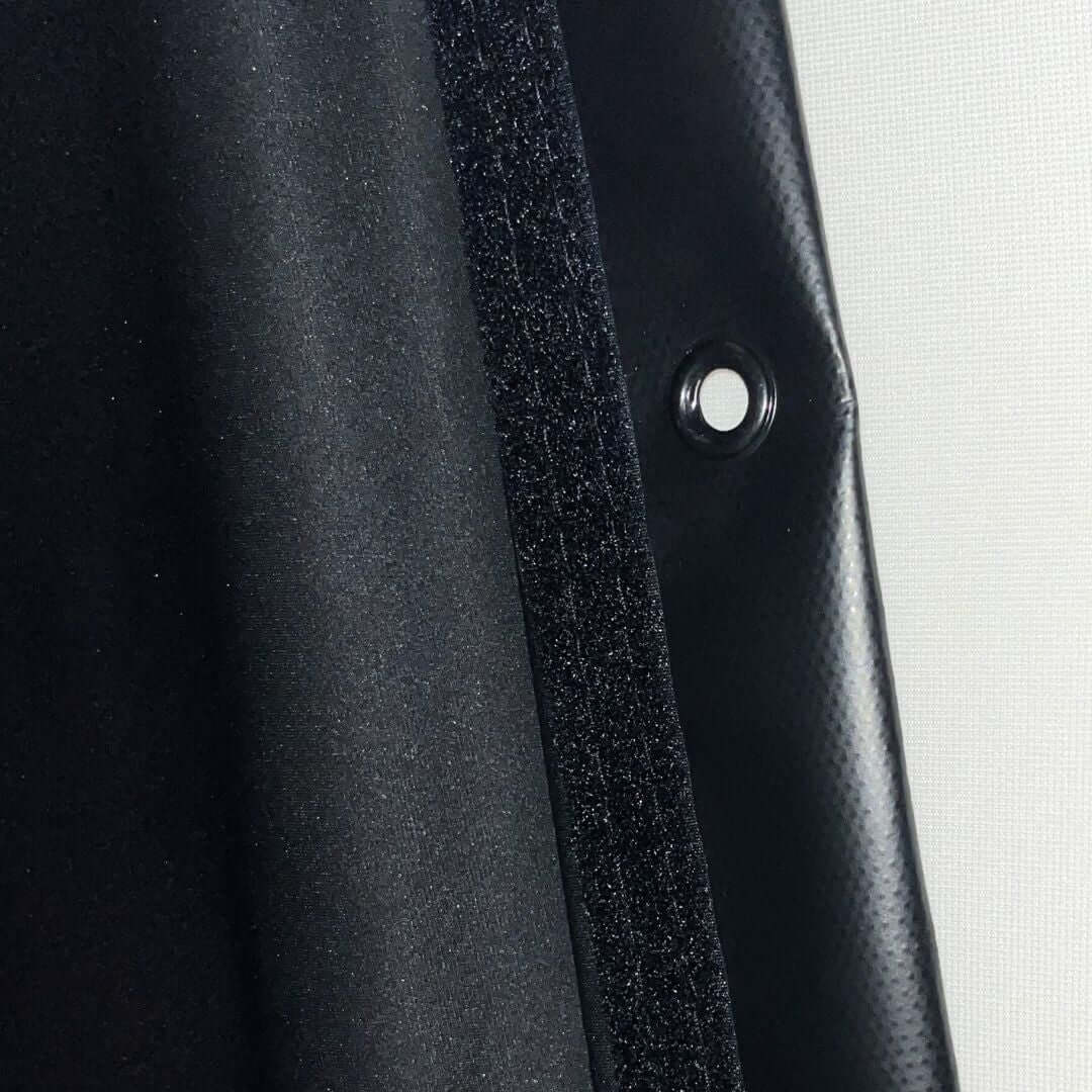 Detail of the Golf Simulator Blackout Screen showing the edge fabric and attachment hole for easy setup.