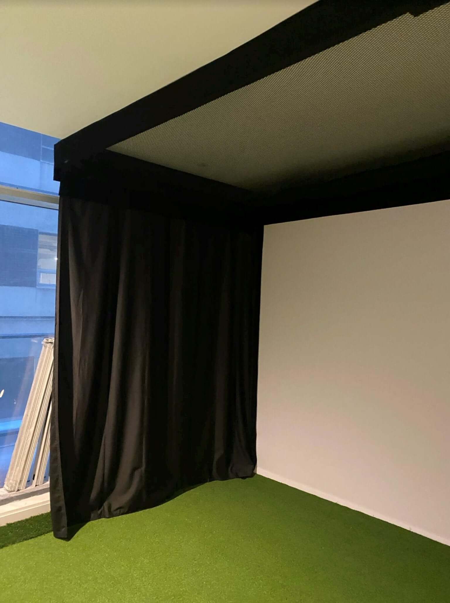SIG Golf Simulator Curtains in a home indoor golf setup with blackout material and retractable design.