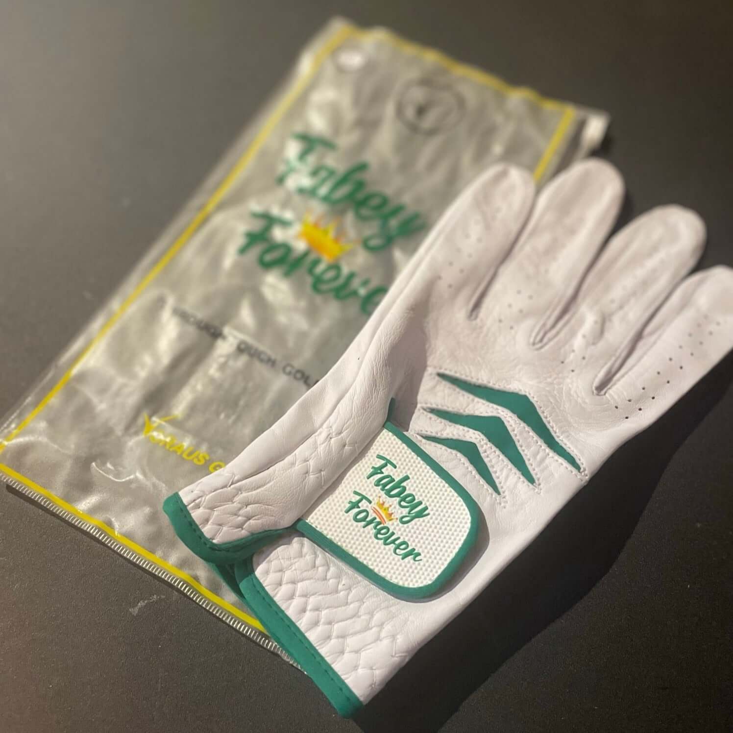 Custom Through Touch Glove displayed with packaging on a dark background.