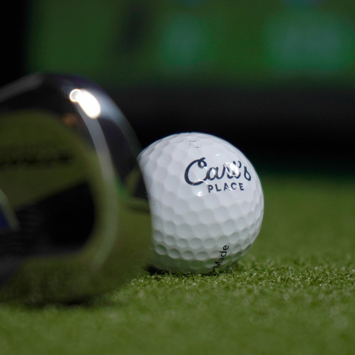 Carl's HotShot Foam Divot Strip and golf ball on a turf mat, showcasing quality golf equipment from Carl's Place.