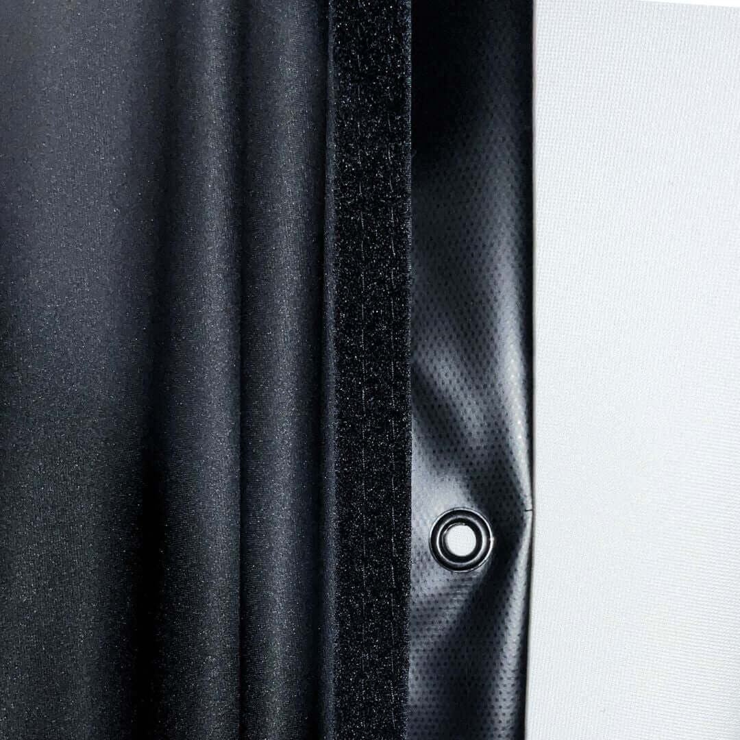Close-up of Golf Simulator Blackout Screen fabric showing black material and grommet attachment.
