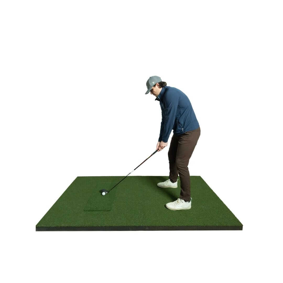 Golfer practicing swing on SIGPRO Softy 4' x 7' Golf Mat with realistic turf and stance.
