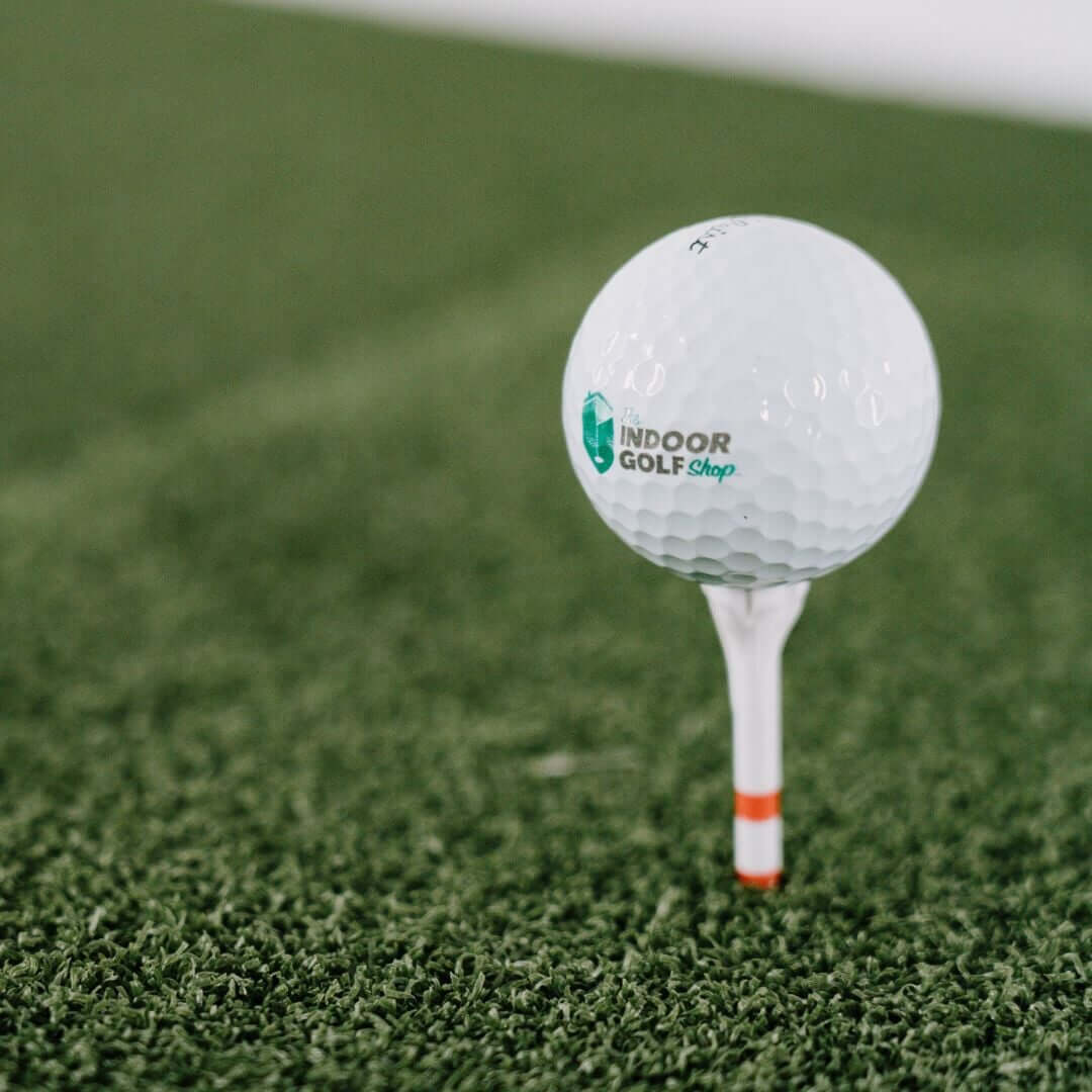 SIGPRO Softy 4' x 7' Golf Mat with a golf ball on a tee in a well-maintained indoor turf setting.